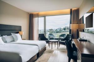 a hotel room with two beds and a desk at Iberostar Selection Lagos Algarve in Lagos