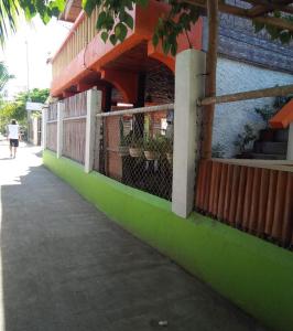a building with a green and colorful wall at Guanna's Place Room and Resto Bar in Malapascua Island