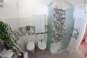 a bathroom with a toilet and a glass shower at APPARTAMENTO L'AIRONE in Balestrate