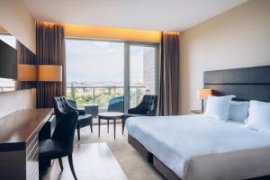 a hotel room with a bed and a large window at Iberostar Selection Lagos Algarve in Lagos