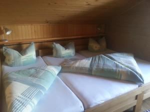 a bunk bed with white sheets and pillows on it at Ferienhütte Rist in Kaltenbach