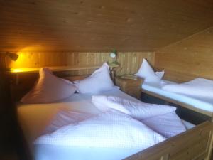 two beds with white pillows in a room at Ferienhütte Rist in Kaltenbach