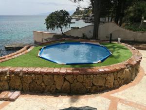 duży basen w kamiennym kręgu przed wodą w obiekcie Villa Agave - SeaFront - Pool Kids - BBQ w mieście Santa Flavia