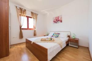 1 dormitorio con 1 cama y suelo de madera en Apartments Blandona, en Biograd na Moru