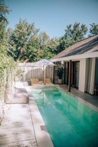 a swimming pool in the backyard of a house at Villa Coralita Gili Trawangan in Gili Trawangan