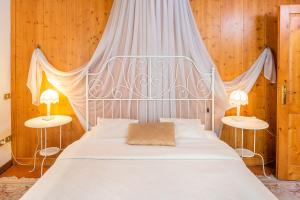 1 dormitorio con 1 cama blanca grande y 2 mesas en Ca' Dinora Appartamenti, en Bardolino