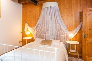 1 dormitorio con 1 cama blanca con dosel en Ca' Dinora Appartamenti, en Bardolino