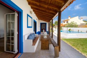 a patio with a wooden bench and a table at WHome | Comporta Family Beach House in Comporta