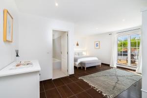 a white room with a bed and a bathroom at WHome | Comporta Family Beach House in Comporta +29 photos