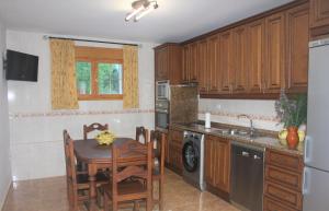 a kitchen with wooden cabinets and a table with chairs at Casa Rural Arenal in Torrijo de la Cañada +34 photos