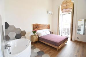 um quarto com uma cama e uma banheira em Sunrise Luxury em Nápoles