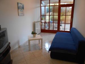 ein Wohnzimmer mit einem blauen Sofa und einem Tisch in der Unterkunft Apartman Snježana in Fažana