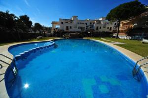 a large blue swimming pool with chairs around it at El Castell Orange Costa in Alcossebre +1 photo
