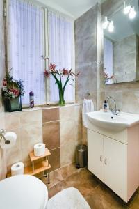 Un baño con lavabo, inodoro y espejo. en Diocletians Heart Apartment, en Split 22 fotos más