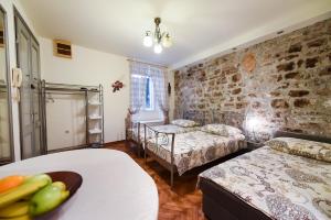 Un dormitorio con dos camas y una pared de ladrillo. en Diocletians Heart Apartment, en Split