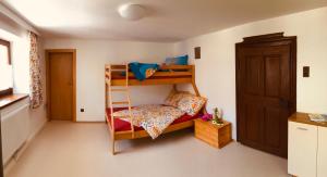 Pokój z 2 łóżkami piętrowymi i drzwiami w obiekcie Ferienwohnung Klampfermühle w mieście Vorchdorf