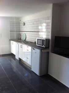 a kitchen with white cabinets and a microwave at Gîte Polema in Marseille