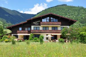 a large building with a mountain in the background at Sportpension Thayer in Piesendorf