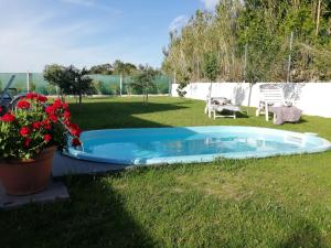 a swimming pool in a yard with flowers in the grass at Casa Salitre in Boiro
