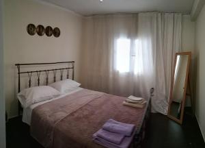 een slaapkamer met een groot bed en een spiegel bij Near Airport And metropolitan Artemis George Cozy Home in Artemida