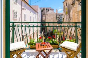 a balcony with two chairs and a table on a city street at LUX AURELIUS in Split Centre Old Town in Split