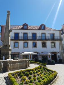 a building with a monument in front of a garden at Alojamento 4 Bicas in Seia