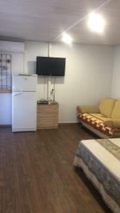 a room with a refrigerator and a couch and a tv at Veranda in Karolino-Buhaz +6 photos