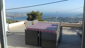 a table and chairs on a balcony with a view at Viva B&B in Anavissos