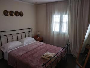 um quarto com uma cama grande e uma janela em Near Airport And metropolitan Artemis George Cozy Home em Artemida