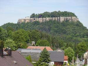 a castle on top of a mountain with houses at Ferienhaus am Malerweg in Königstein an der Elbe +3 photos