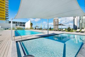 een groot zwembad met een witte luifel erboven bij Air On Broadbeach-Stunning Ocean Views in Gold Coast