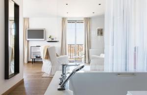 a white bathroom with a tub and a living room at Castel Beau Site in Perros-Guirec +37 photos