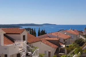 a group of houses with the ocean in the background at Rooms Hvar in Hvar