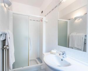 a white bathroom with a sink and a shower at Locanda Sant' Anna in Argegno