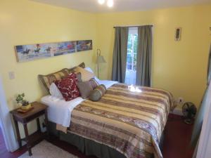 a bedroom with a large bed with pillows on it at Historic Santa Rosa Cottage in Santa Rosa