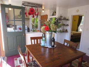 a kitchen with a wooden table with a vase of flowers at Historic Santa Rosa Cottage in Santa Rosa