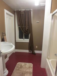 a bathroom with a white sink and a window at Historic Santa Rosa Cottage in Santa Rosa