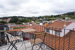a balcony with two chairs and a view of a city at Casa Portas 8&10 in Lamego