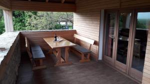 a patio with a table and a bench and a glass door at Weekend House Petar in Lusnić