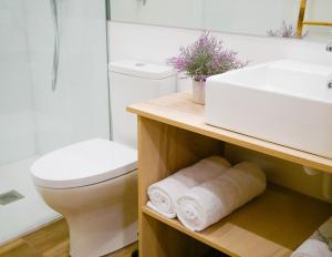 łazienka z białą toaletą i umywalką w obiekcie Apartamentos Antares 2 w mieście Milladoiro +37 zdjęć