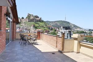 a patio with a table and chairs on a balcony at Penthouse Apartment 401 in Tbilisi City