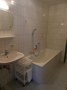 ein Badezimmer mit einer Badewanne und einem Waschbecken in der Unterkunft Hotel Krone in Oberperfuss