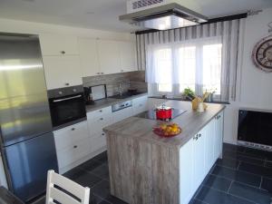 a kitchen with white cabinets and a wooden island at Am Keschtewaeldele **** in Forbach