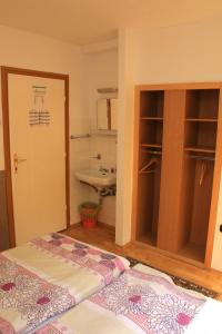a small bathroom with a bed and a sink at Touring & Sport Hotel Siófok in Siófok