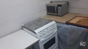 a kitchen with a stove and a microwave at Appartement meublé Sfax Touristique IHEC in Sfax +7 photos