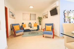 Una sala de estar con sillas, un sofá y una mesa. en Holidays Nazaré marginal, en Nazaré