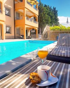 una bebida y galletas en una mesa junto a la piscina en Villa Ljubica en Vodice