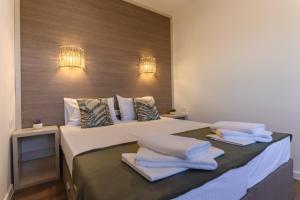 a bedroom with a large bed with towels on it at Apartments My Przno in Sveti Stefan