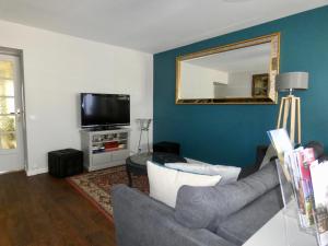 a living room with a couch and a mirror at "LA VERANDA" Gîte in Verdigny