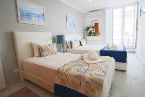 Un dormitorio pequeño con dos camas y una ventana. en Holidays Nazaré marginal, en Nazaré